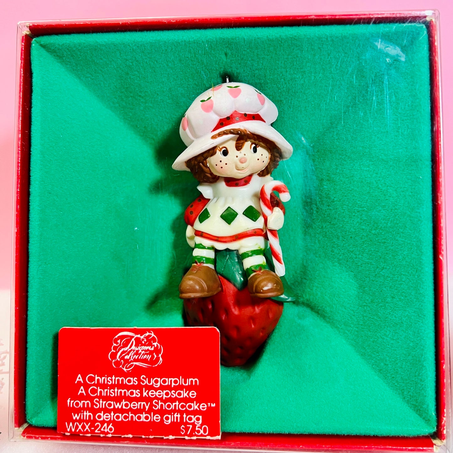 Boxed 1982 Vintage Strawberry Shortcake Ceramic Christmas Ornament: Strawberry Herself with Candy Cane sitting on a Strawberry! - Dolly Magic
