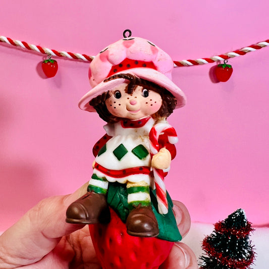 1982 Vintage Strawberry Shortcake Ceramic Christmas Ornament: Strawberry Herself with Candy Cane sitting on a Strawberry! - Dolly Magic