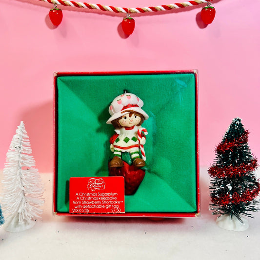 Boxed 1982 Vintage Strawberry Shortcake Ceramic Christmas Ornament: Strawberry Herself with Candy Cane sitting on a Strawberry! - Dolly Magic